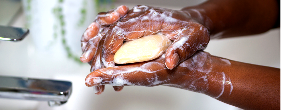 Close-up of hands lathering up with a bar of soap.